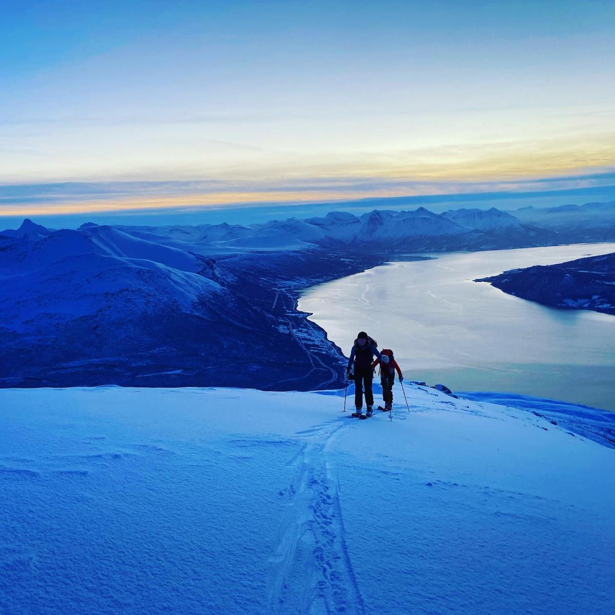 a group of people riding skis on top of a snow covered mountain