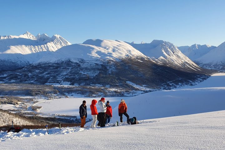 a group of people standing on top of a snow covered mountain