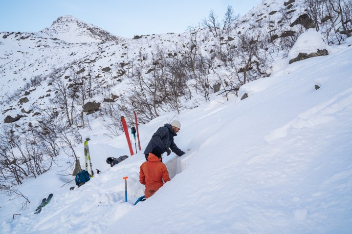a man riding a snowboard down a snow covered slope