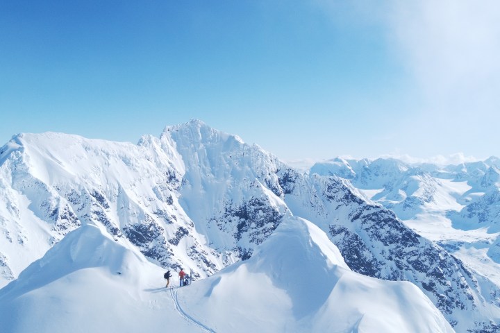 a group of people standing on top of a snow covered mountain