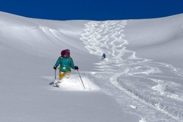 a man riding skis down a snow covered slope