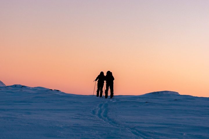 a person riding a horse in front of a sunset