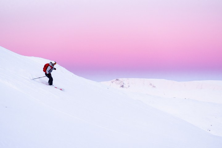 a man riding skis down a snow covered slope